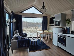 eine Küche und ein Wohnzimmer mit einer Couch und einem Tisch in der Unterkunft Úthlíd Cottages in Úthlid + 37 Fotos