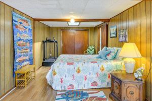 Un dormitorio con una cama y una mesa con una lámpara. en Boathouse with Screened Porch Riverfront Escape!, en Chiefland