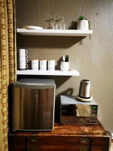 a microwave sitting on top of a counter next to a coffee maker at Indulgent Escape, Jet Bath, Stunning Views Boma Firepit -Retreat from the City in Roodepoort