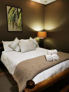 a bedroom with a bed with towels on it at Indulgent Escape, Jet Bath, Stunning Views Boma Firepit -Retreat from the City in Roodepoort