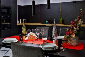 a dining room table with a red tablecloth and christmas decorations at Nowoczesne Apartamenty typu Superior - Bulwary Rabka Zdrój - Balia - Blisko Park Zdrojowy in Rabka