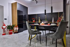 a kitchen with a dining room table and chairs at Nowoczesne Apartamenty typu Superior - Bulwary Rabka Zdrój - Balia - Blisko Park Zdrojowy in Rabka