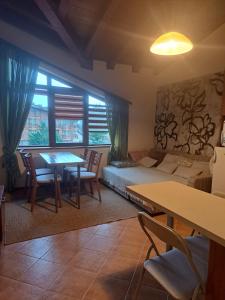 a living room with a bed and a table and chairs at Pirin Golf hotel, Apartment Chalet style in Razlog
