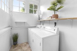a white laundry room with a washer and dryer at Remodeled Farmhouse, Central, with Yoga room in Durham +44 photos