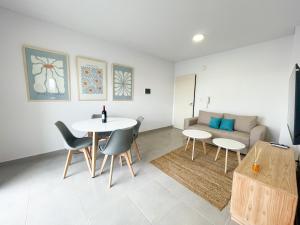 a living room with a table and chairs and a couch at Saavedra 118 8D by depptö in Bahía Blanca