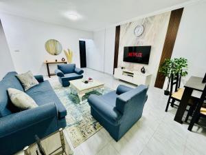 uma sala de estar com sofás azuis e uma TV em Relaxing Apartment with garden view in New Cairo em Cairo