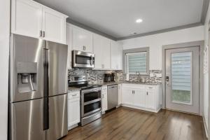 ナッシュビルにあるLuxury 4 Bedroom Home, Heart of the Entertainmentの白いキャビネットとステンレス製の冷蔵庫を備えたキッチン