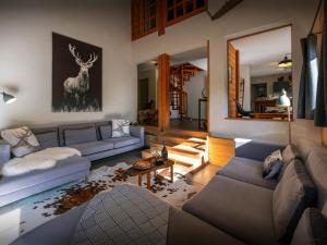 a living room with couches and a deer painting on the wall at Chalet Paravis - OVO Network in La Clusaz