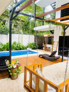 a patio with a swing and a swimming pool at Encantador Loft con Piscina 1 BDR in Santa Teresa Beach