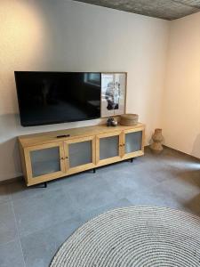 a flat screen tv sitting on top of a wooden entertainment center at Ferienwohnung an der Aitrach in Aitrach +17 photos