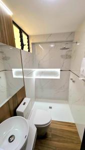 a white bathroom with a toilet and a sink at LUJOSO DEPARTAMENTO VIP EN ESTRENO capacidad08 in Tacna