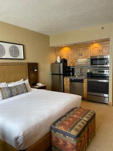 a hotel room with a large bed and a kitchen at The Grand Summit Hotel in the Canyons Village - Walk to Ski Lift - Pool, Gym, Spa, More! in Park City