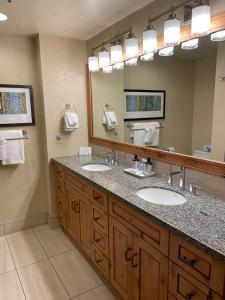 a bathroom with two sinks and a large mirror at Grand Summit Hotel, Ski In Out, Pool, Hot Tub, Gym, Perfect Location! in Park City