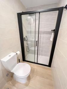 a bathroom with a toilet and a glass shower at El rincón de María in Torremolinos