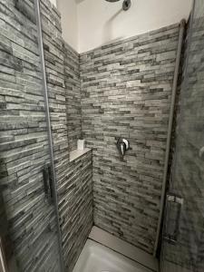 a bathroom with a shower with a stone wall at La Casetta in Rome +10 photos