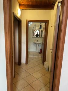 einen Flur eines Badezimmers mit einem Waschbecken und einem Spiegel in der Unterkunft La corte dei celti la fonte 1 in San Benedetto Del Querceto + 40 Fotos