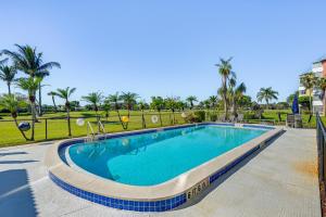 a swimming pool at a resort with palm trees at Lanai and Golf Course View Cozy Condo in Naples! in Naples