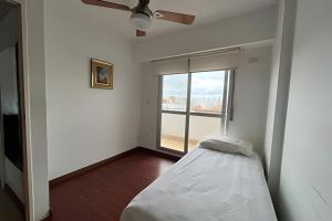 a white room with a bed and a window at Moderno departamento zona centro in Rosario