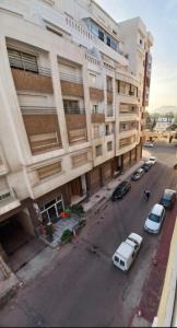 an apartment building with cars parked in front of it at Appartement Dari proche du centre ville in Agadir