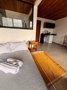 a living room with a bed and a table at Flats Praia Comprida in Abraão