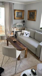 a living room with a couch and a table at Das Edelweiß Apartment by ALA Living - stilvoll Urlauben mit traumhaftem Ausblick, Sonnenterrasse, 200m zur Zugspitzbahn! in Grainau