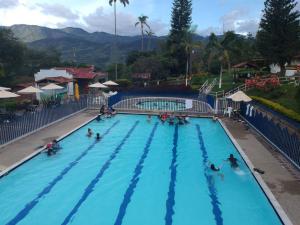 a group of people in a swimming pool at a resort at Yarumito Finca Hotel Cabaña Gardenia in Barbosa