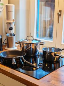 two pots and pans sitting on top of a stove at Das Edelweiß Apartment by ALA Living - stilvoll Urlauben mit traumhaftem Ausblick, Sonnenterrasse, 200m zur Zugspitzbahn! in Grainau +17 photos