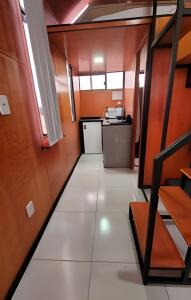 an empty room with a white floor and a kitchen at Chalé Henri Salvador na Vinícola Reconvexo in Morro do Chapéu