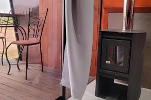 a television and a table and chair on a porch at Chalé Henri Salvador na Vinícola Reconvexo in Morro do Chapéu