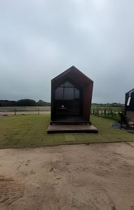 a large black object sitting on a grass field at Chalé Henri Salvador na Vinícola Reconvexo in Morro do Chapéu