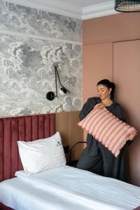 kobieta trzyma poduszkę na łóżku w obiekcie Havana Premium Family Stay by Lion Apartments Sopot w mieście Sopot