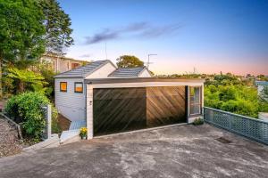 a garage with a large gate in front of a house at The Aotearoa Room in Auckland