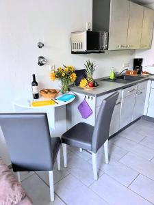 ヴィーク・アウフ・リューゲンにあるstayMA Strandhaus Wiek - Erholen Kitesurfen Wandern und Meerのキッチン(テーブル、椅子2脚、電子レンジ付)