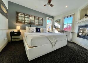 a bedroom with a white bed and windows at White Porch Inn in Provincetown