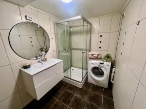 a bathroom with a sink and a washing machine at Polar - TAG-apartments in Tromsø +15 photos