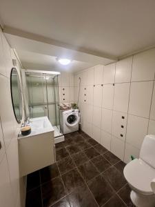 a bathroom with a sink and a washing machine at Polar - TAG-apartments in Tromsø
