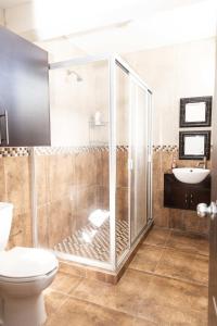 a bathroom with a shower and a toilet and a sink at Family House with 4 Bedrooms Oaxaca in Oaxaca City