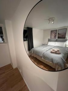 a circular mirror in a bedroom with a bed at Polar - TAG-apartments in Tromsø