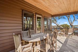 a wooden porch with a table and chairs on a deck at Windows on the Water in Pawleys Island