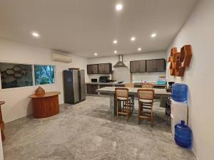 a kitchen with a table and chairs and a refrigerator at Villa Douce in Thongsala