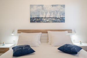 a bedroom with a bed with two pillows and sailboats at Apartments Ranko in Zavalatica