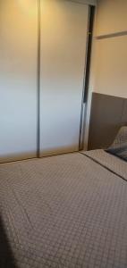 ein Schlafzimmer mit einem Bett mit einer Tür und einem gefliesten Boden in der Unterkunft Apartamento no Edifício Time Maceió in Maceió