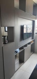 ein Wohnzimmer mit einem TV und einem weißen Boden in der Unterkunft Apartamento no Edifício Time Maceió in Maceió