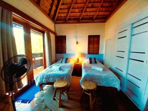 una stanza con due letti e una finestra di MOOREA - Villa Ana Mua a Papetoai Altre 37 foto