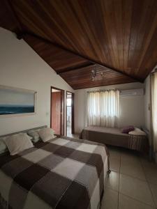a bedroom with two beds and a wooden ceiling at By Búzios Loft in Búzios