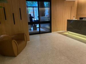 a lobby with a chair and a person in the window at Studio 309 Luxo no coração do Rio - piscina, academia, sala de reunião in Rio de Janeiro +42 photos