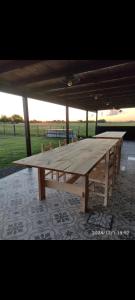 una gran mesa de picnic de madera sentada bajo un pabellón en Poyecto Laguna, en San Miguel del Monte