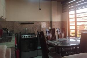a kitchen and dining room with a table and a stove at Habitación familiar Maoservi in Soacha