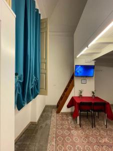a room with a red table and a blue curtain at casa catania termini home 3 in Catania