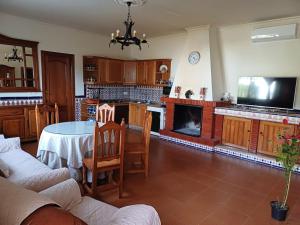a large living room with a table and a tv at Rincón Subbético in Luque